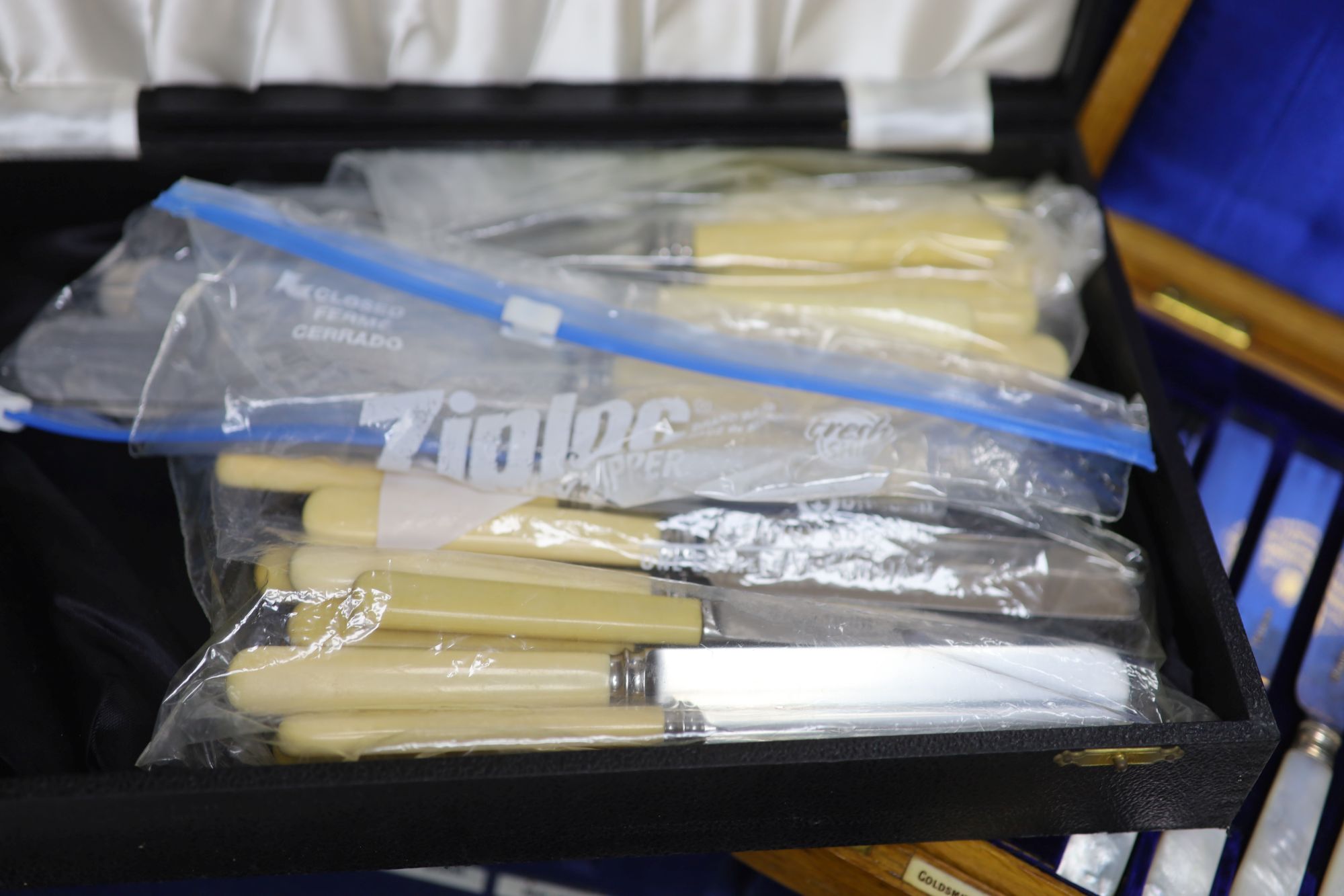 A cased set of silver dessert knives and forks and two other boxes